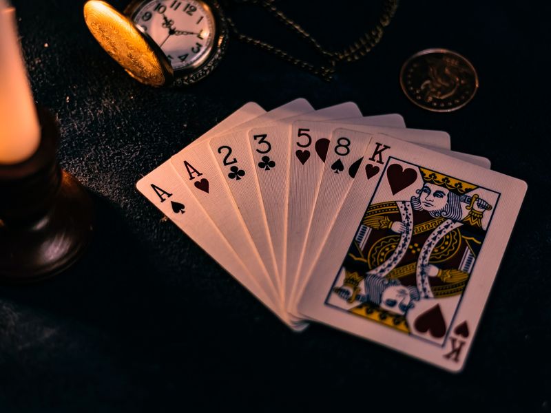This image shows a deck of cards on a dark table.