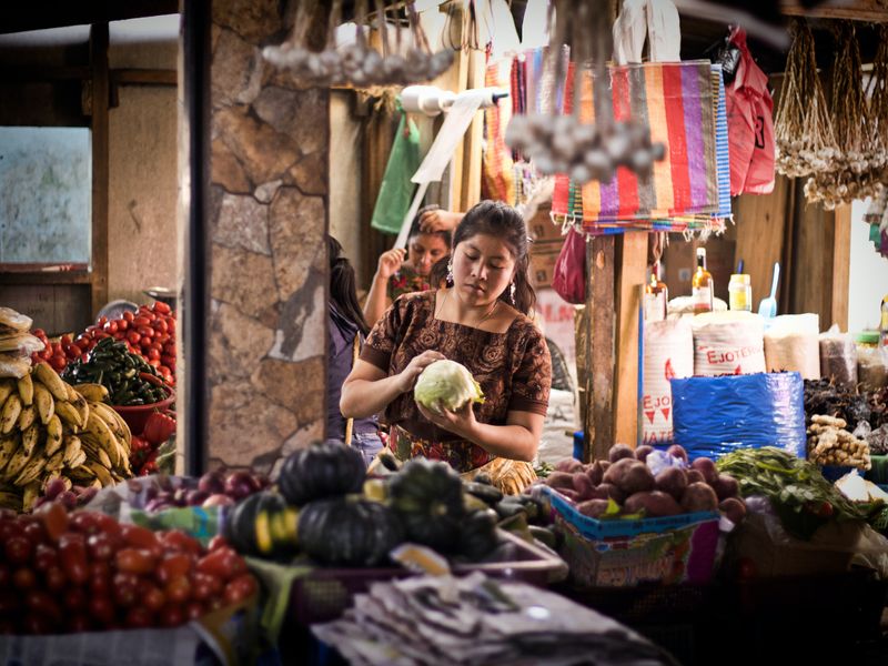 A girl selling vegetables at market.
